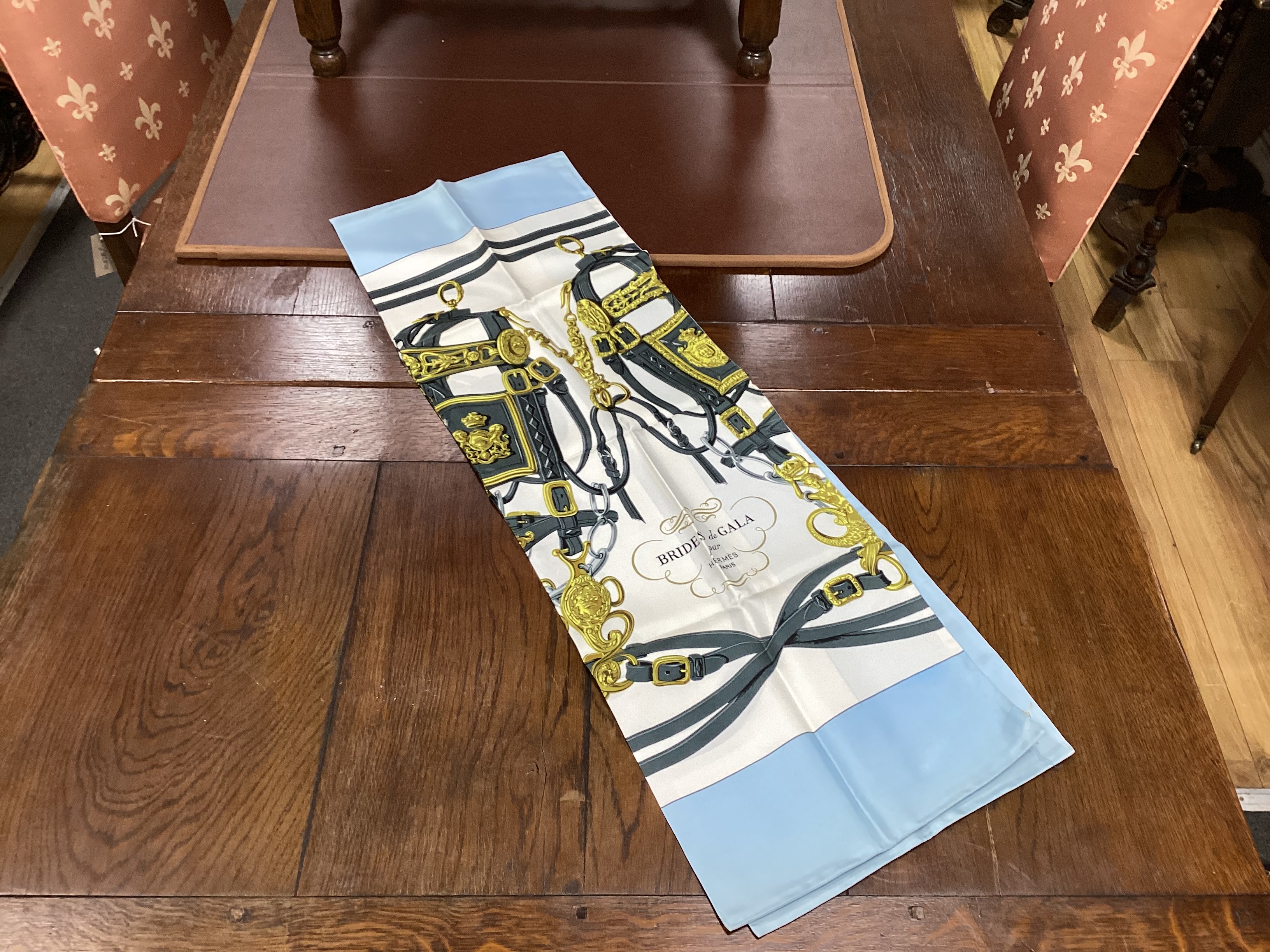 Four vintage Hermes silk scarves including one retailed by Harrods comprising, Selles A Housse, Roues de Canon, Passementerie and a rectangular Brides de Gala example